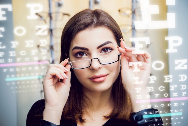 Chica joven con gafas en el fondo claro.