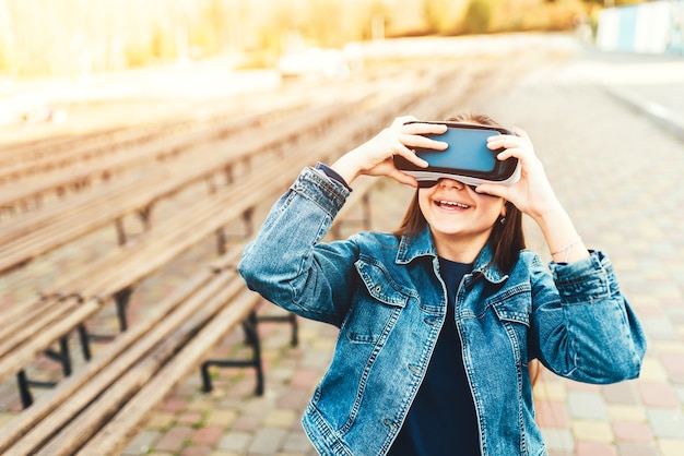 Chica joven en gafas de realidad virtual en el parque