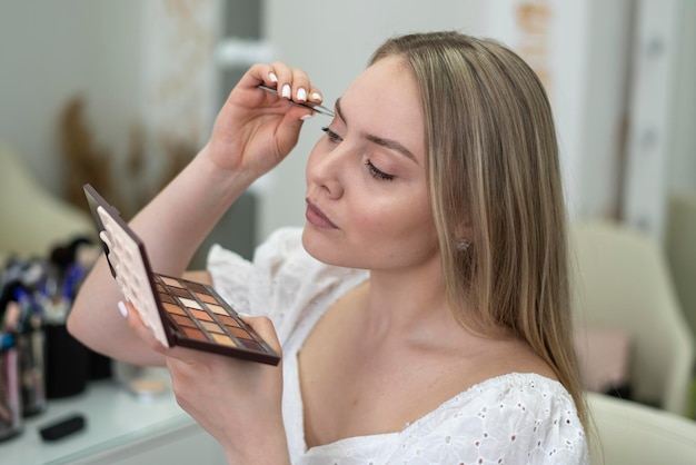 chica joven haciendo maquillaje ella misma en la rutina diaria de la mañana