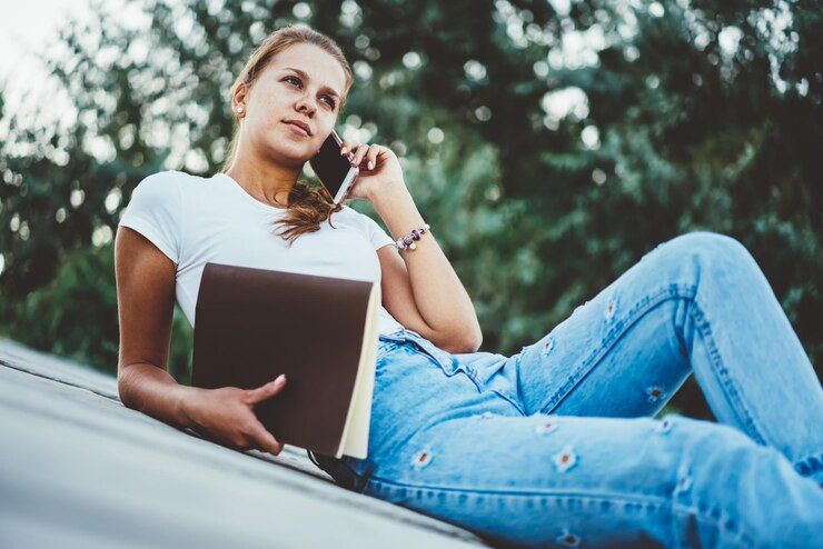 Foto chica joven hipster llamando al servicio de atención al cliente para consultar usando el teléfono móvil al aire libre