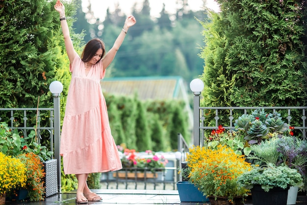 Chica joven en un jardín de flores entre rosas hermosas. Olor a rosas