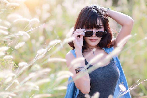 Chica joven y linda que tiene un momento feliz y enoying entre campo de hierba en la naturaleza