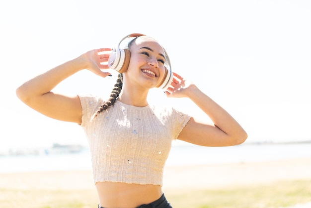 Chica joven marroquí al aire libre escuchando música