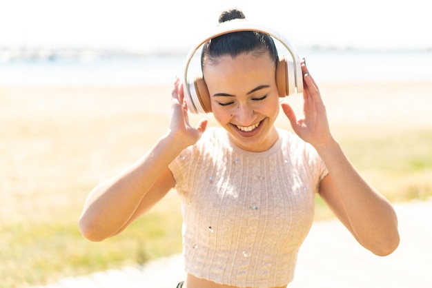 Chica joven marroquí al aire libre escuchando música