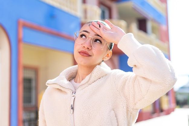 Chica joven marroquí al aire libre con gafas y cansado