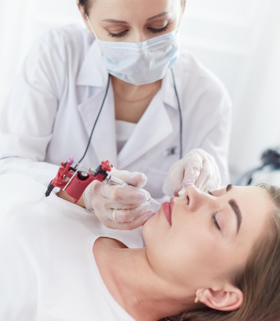 Una chica joven con micropigmentación de maquillaje permanente de labios rojos