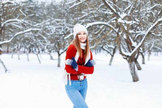 Chica joven de moda en una cálida ropa de invierno vintage en día de nieve de invierno