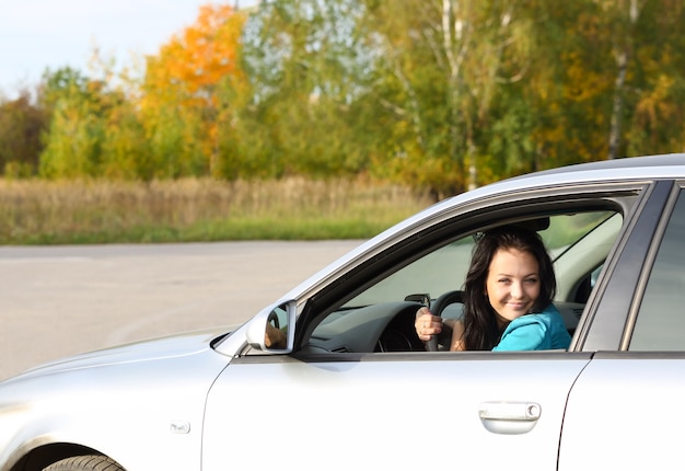 Chica joven morena conduciendo un coche