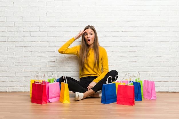 Una chica joven con muchas bolsas de compras acaba de darse cuenta de algo y tiene la intención de encontrar la solución