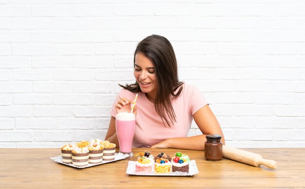 Chica joven con muchos pasteles diferentes