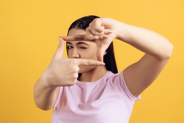 Chica joven muestra gesto de tomar fotografías.