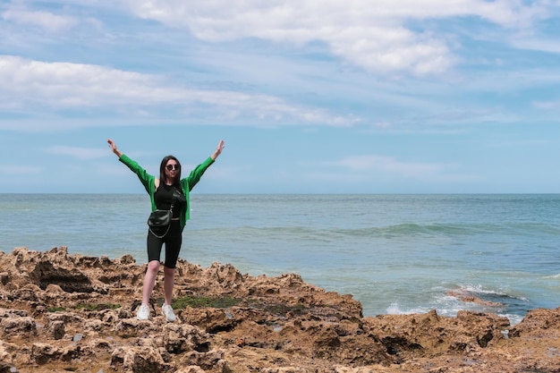 Chica joven en la orilla rocosa del mar del norte