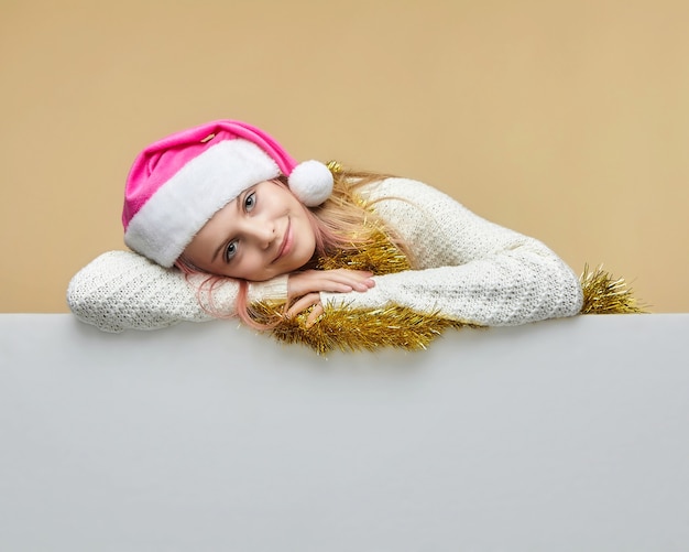 Chica joven con oropel y gorro de Papá Noel