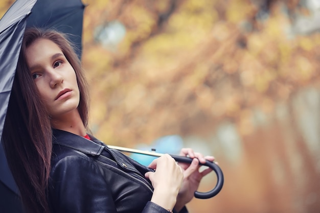 Chica joven en otoño en tiempo lluvioso