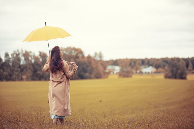 Chica joven en otoño en tiempo lluvioso