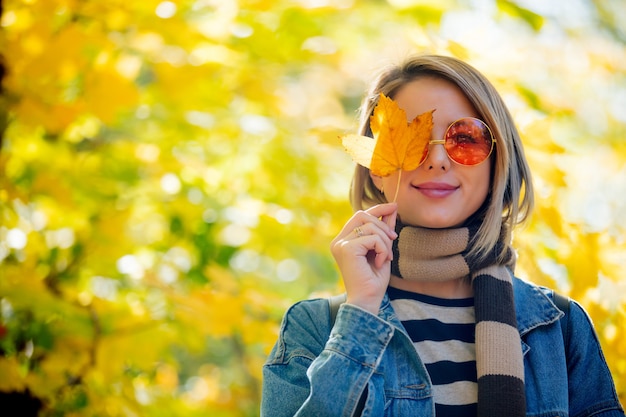 Chica joven en el parque en otoño temporada.