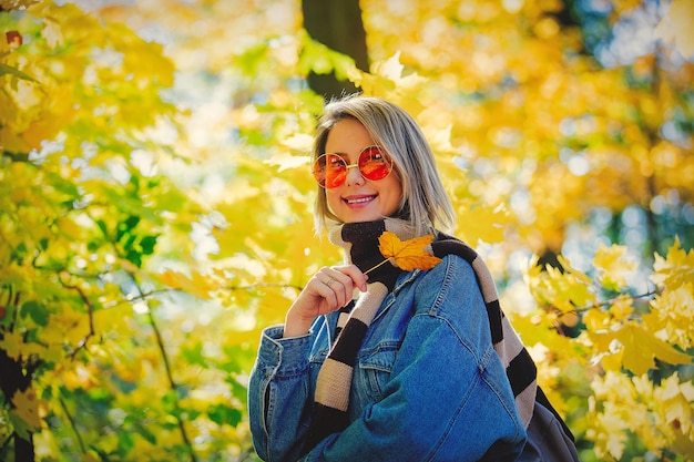 Chica joven en el parque en otoño temporada.