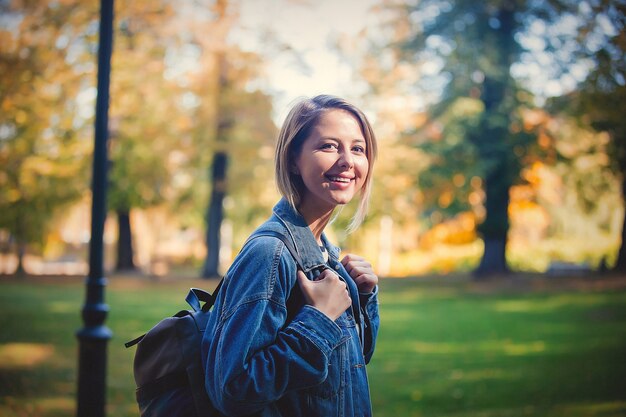 Chica joven en el parque de la temporada de otoño