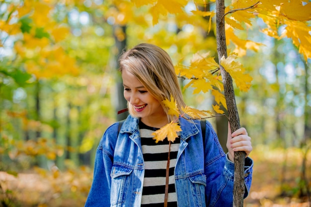 Chica joven en el parque de la temporada de otoño