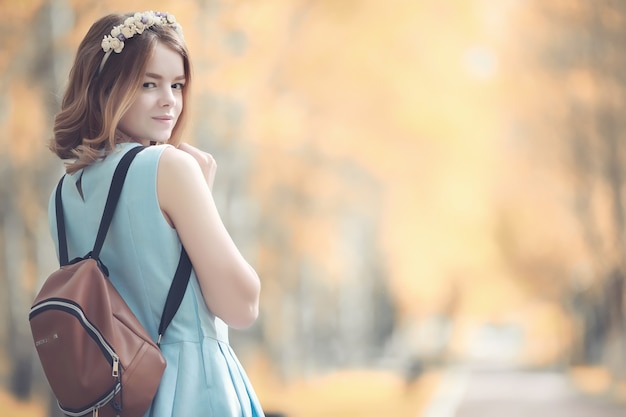 Chica joven en un paseo por el parque de otoño