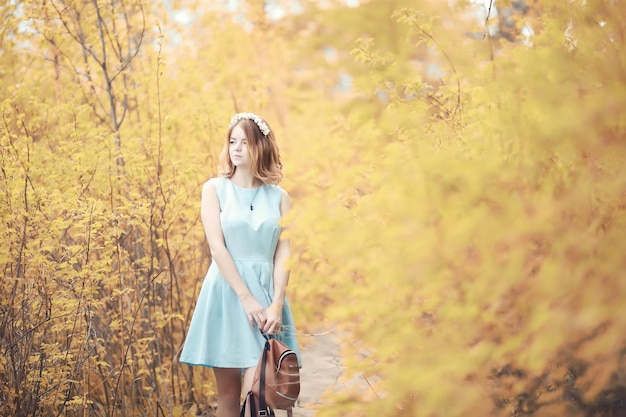 Chica joven en un paseo por el parque de otoño