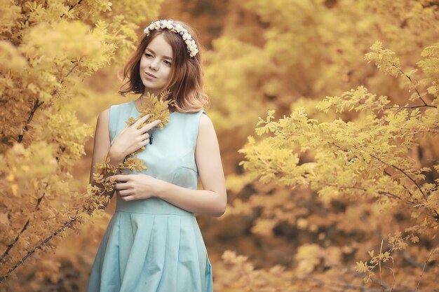 Chica joven en un paseo por el parque de otoño