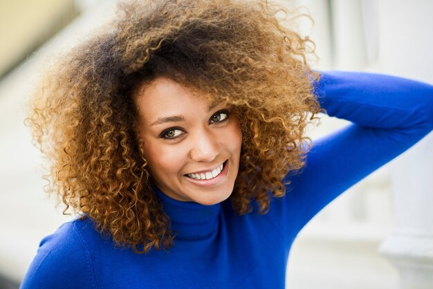 Chica joven con peinado afro en el fondo urbano