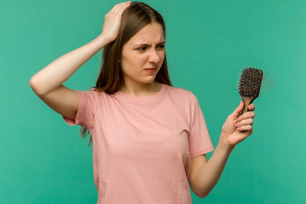 Chica joven con un peine y cabello problemático en azul