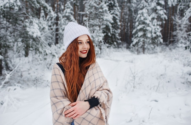 Chica joven con pelo largo rojo en un paisaje de invierno.