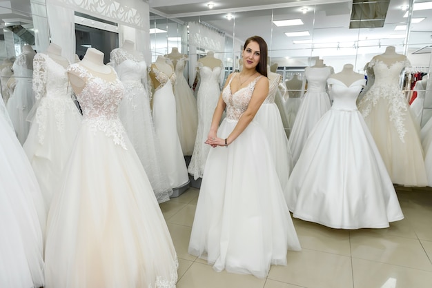 Foto chica joven se está probando un hermoso vestido de novia en la tienda