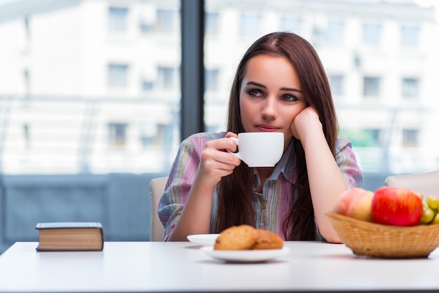 Chica joven que desayuna en la mañana