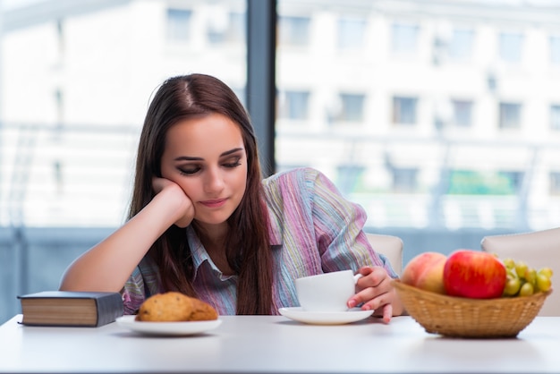 Chica joven que desayuna en la mañana