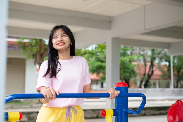 Chica joven que hace ejercicio con el ejercicio colorido del equipo