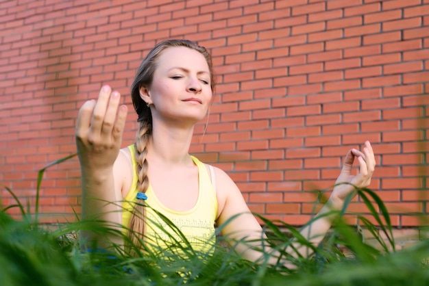 Chica joven que hace yoga en el patio trasero