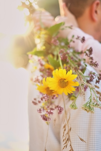 Foto chica joven que sostiene un ramo de flores silvestres en manos