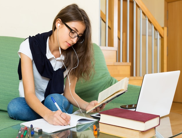 chica joven que usa la computadora portátil en casa