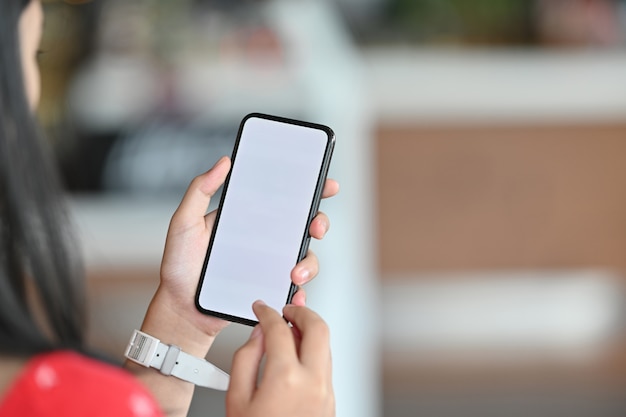 Chica joven que usa el teléfono móvil. Teléfono inteligente de pantalla en blanco para montaje.