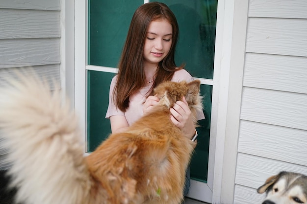 Chica joven en ropa casual abrazando golden retriever mientras está sentado en el suelo