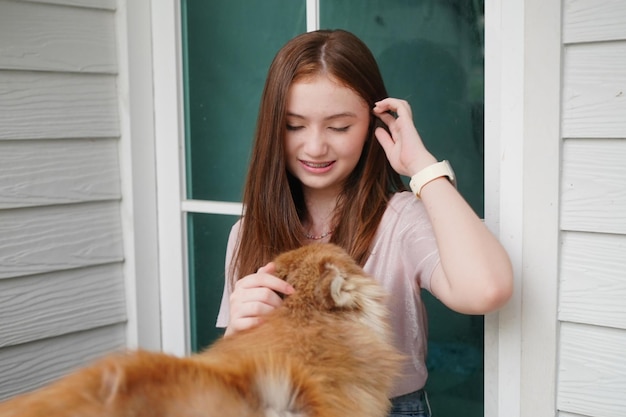 Chica joven en ropa casual abrazando golden retriever mientras está sentado en el suelo