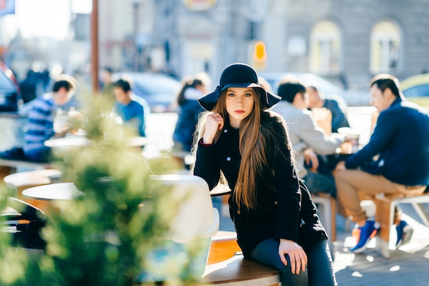 Chica joven en ropa elegante posando en la ciudad