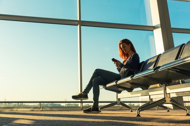 Chica joven en la sala de espera de la estación.