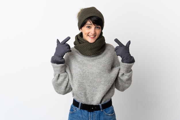 Chica joven con sombrero de invierno dando un pulgar hacia arriba gesto