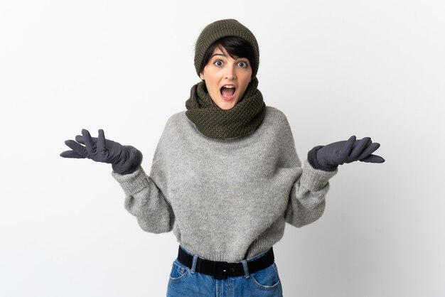 Chica joven con sombrero de invierno con expresión facial sorprendida