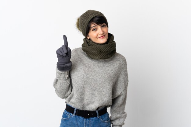 Foto chica joven con sombrero de invierno mostrando y levantando un dedo en señal de lo mejor