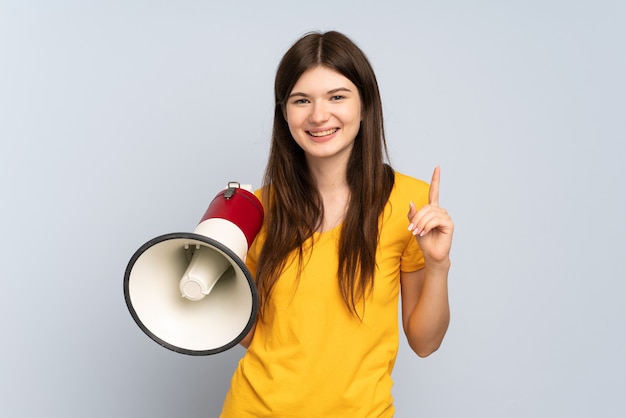 Chica joven sosteniendo un megáfono y apuntando hacia una gran idea