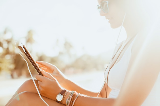 Chica joven con una tablet en sus piernas