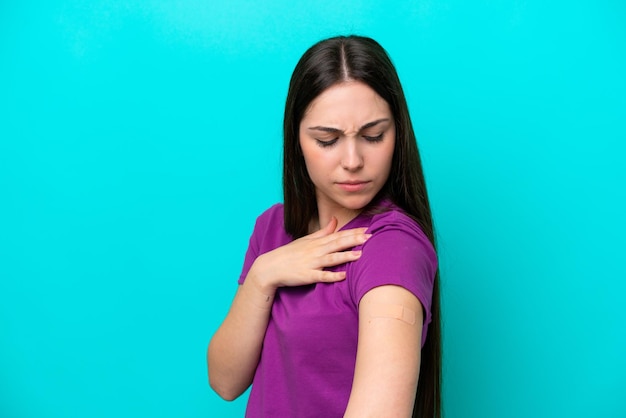 Chica joven con tiritas aislado sobre fondo azul con expresión triste