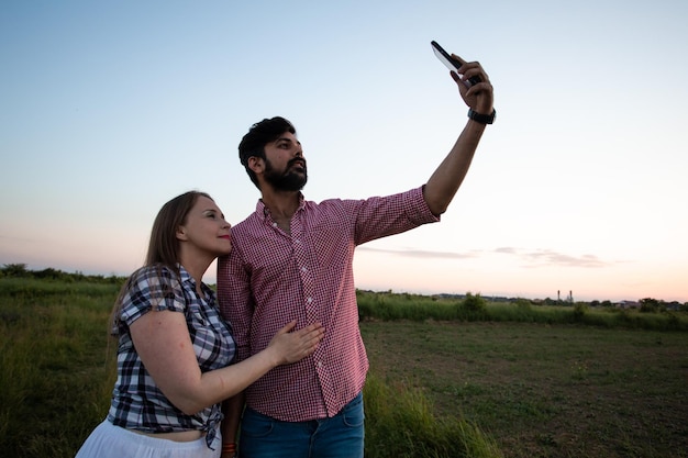 Chica joven tomando selfie en campo de trigo de verano