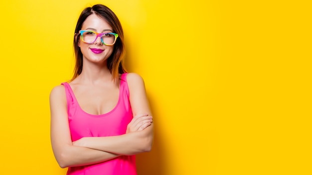 Chica joven en traje de baño de una pieza rosa con anteojos