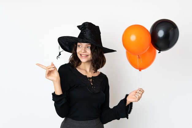 Chica joven en traje de Halloween sobre pared blanca